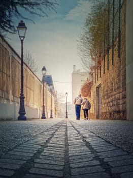 Senior couple walking outdoors together. Healthy lifestyle, elder love concept. Happy old pair strolling on the town alley in Asnieres sur Seine, a Paris suburb, France