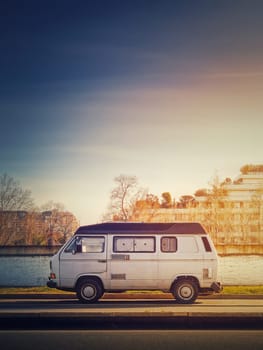 Old van parked on the edge of the street in the sunset sky background, Asnieres sur Seine, Paris suburb, France