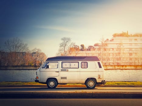 Old van parked on the edge of the street in the sunset sky background, Asnieres sur Seine, Paris suburb, France