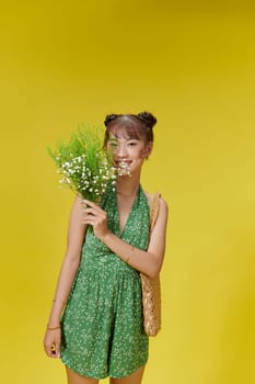 Young girl with large bouquet of small pink wildflowers laughs