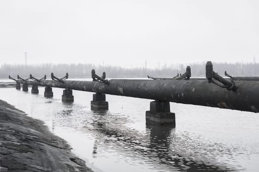 Old steel rusty abandoned pipes of the water cooling pipeline system of the combined heat and power industrial plant.