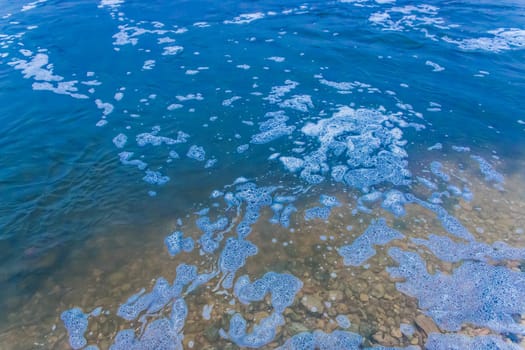 Foam abstract natural foamy pattern on the surface of the water lake background texture.