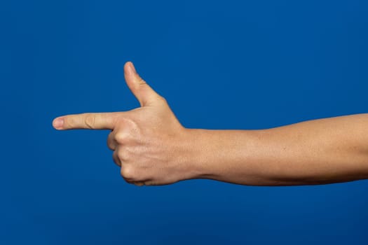 Strong hand of man pointing to the side in the shape of a gun, isolated on background