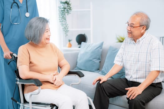 A contented senior couple and their in-home nurse. Elderly female in wheelchair with her young caregiver.