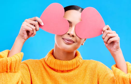 Heart eyes, cover and woman smile with happiness and excited for love, valentines day or studio emoji. Happy, loving or person on isolated blue background, creative romance paper and show care symbol.