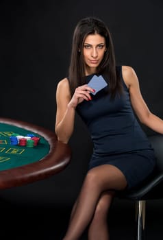 sexy woman with poker cards and chips. Female player in a beautiful black dress