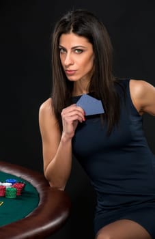 sexy woman with poker cards and chips. Female player in a beautiful black dress