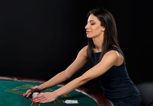 sexy woman with poker cards and chips. Female player in a beautiful black dress, bet chips