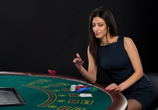 sexy woman with poker cards and chips. Female player in a beautiful black dress, bet chips