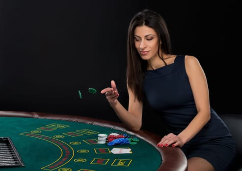 sexy woman with poker cards and chips. Female player in a beautiful black dress, bet chips