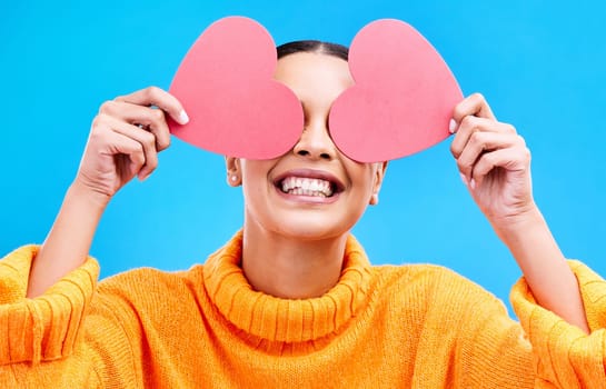 Heart eyes, cover and woman with happiness and excited about love, valentines day or emoji. Happy, smile and person with isolated blue background, loving or creative romance paper symbol to show care.