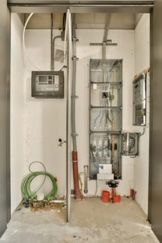 the inside of a building with pipes and electrical equipment on the wall, including an air conditioner in the background