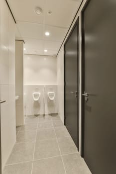 a bathroom with two toilets in the middle and one on the other side there is an open door that leads to another room