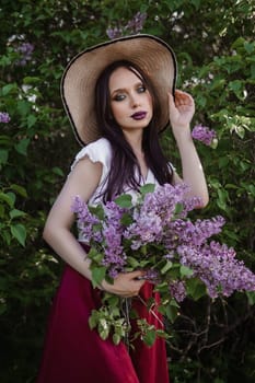 A fashionable girl with dark hair, a spring portrait in lilac tones in summer. Bright professional makeup