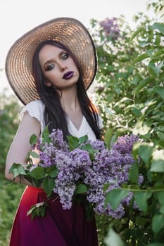 A fashionable girl with dark hair, a spring portrait in lilac tones in summer. Bright professional makeup