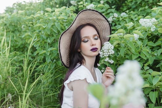 A fashionable girl with dark hair, a spring portrait in lilac tones in summer. Bright professional makeup