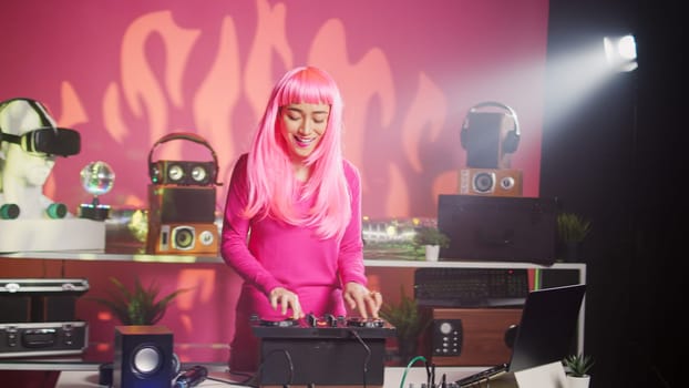 Smiling dj playing electronic sound using mixer console, creating unique remix for fans during techno party in nightclub. Musician enjoying performing music using professional audio equipment