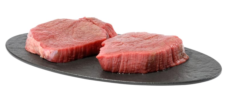 Two round raw beef steak on a black oval cutting board, white isolated background