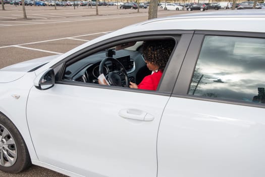 African Businesswoman in red coat using disinfectant wet tissue wipe on steering wheel, prevent epidemic coronavirus in her car, Cleaning, Antiseptic High quality photo