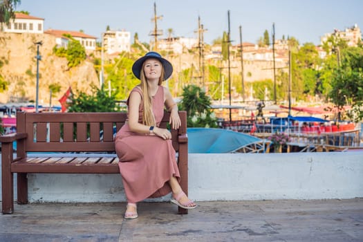 Woman tourist in Old town Kaleici in Antalya. Turkiye. Panoramic view of Antalya Old Town port, Taurus mountains and Mediterrranean Sea, Turkey.