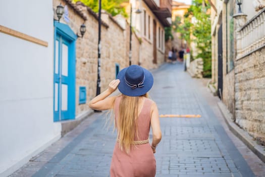 Woman tourist in Old town Kaleici in Antalya. Turkiye. Panoramic view of Antalya Old Town port, Taurus mountains and Mediterrranean Sea, Turkey.