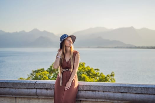 Happy woman tourist on background of Antalya sea and mountain views, sea in Turkey Antalya City. female tourist traveler discover interesting places and popular attractions and walks in the old city Kalechi of Antalya, Turkey. Turkiye.