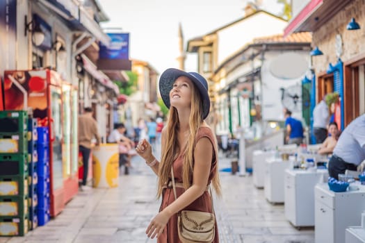 Happy woman tourist on background of old street of Antalya. female tourist traveler discover interesting places and popular attractions and walks in the old city Kalechi of Antalya, Turkey. Turkiye.