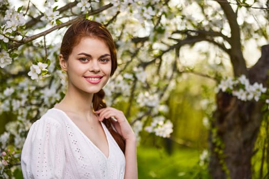 Beautiful young woman. model in white dress stands in white flowers. Horizontal photo. copy space.High quality photo