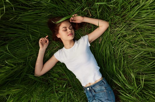 happy woman lies in green grass field. High quality photo