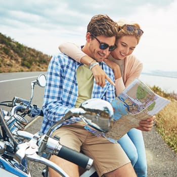 Go wherever love takes you. a couple using a map while out on a road trip