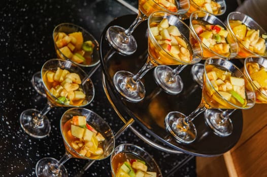 A buffet table with glasses of punch with fruits and juice