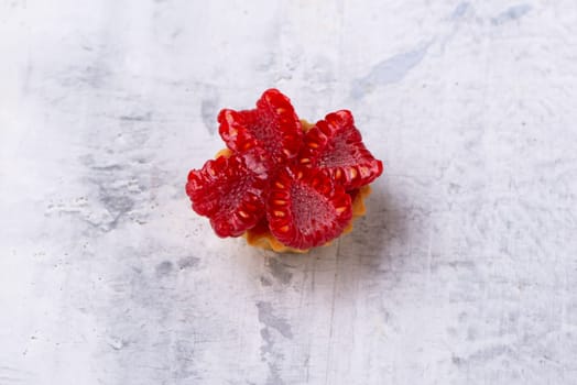 A top view shot of decorated Red raspberry on white marble surface