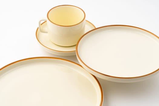 A set of white and brown ceramic plate and cup on a white background