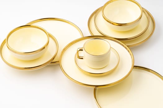 A set of golden luxury ceramic kitchen utensils on a white background