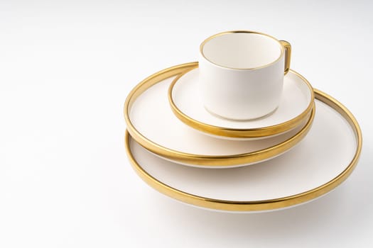 A set of white and brown ceramic plate and cup on a white background