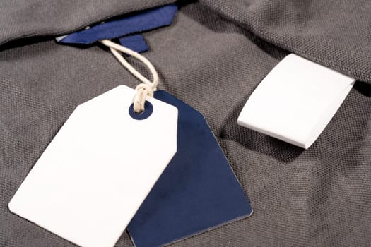 A closeup shot of white blue clothing tags on a string with copy space and a blank tag