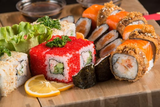 A closeup shot of a sushi set on a wooden plate