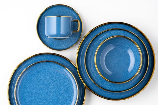 A set of blue ceramic plates and cup on a white background. Top view