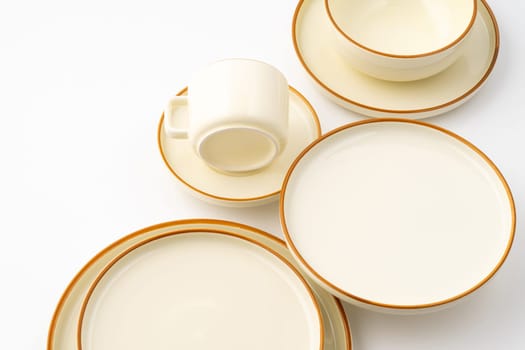 A set of white and brown ceramic plate and cup on a white background