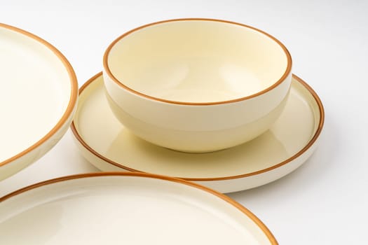 A set of white and brown ceramic plate and cup on a white background