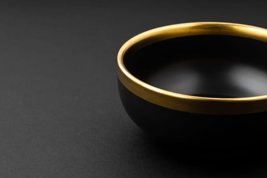 A set of black and golden ceramic plate on a black background