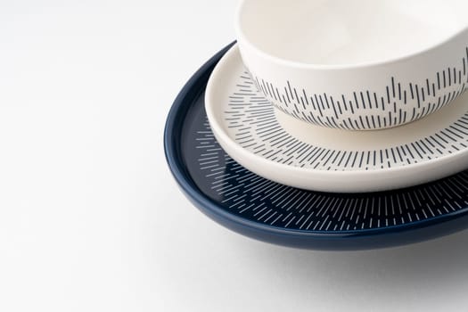 A closeup shot of a blue and white mug on a saucer with a white background