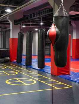 A vertical shot of boxing bags in the sports complex