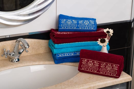 A closeup shot of a stack of folded colorful bamboo towels on a bathroom cabinet