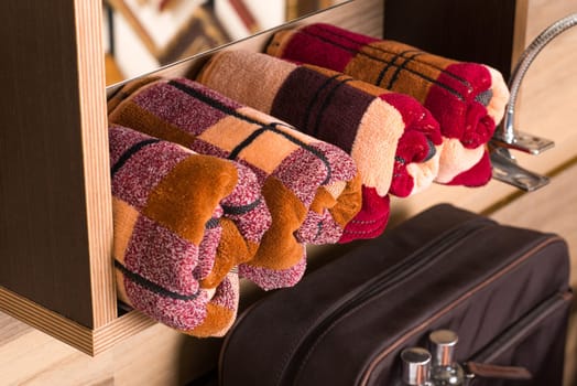 A closeup shot of folded plaid bamboo towels on a bathroom shelf