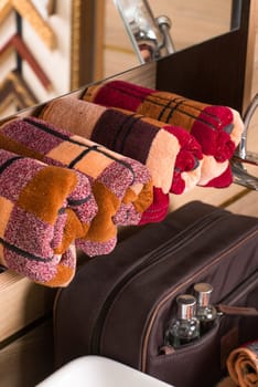 A vertical shot of folded plaid bamboo towels on a bathroom shelf