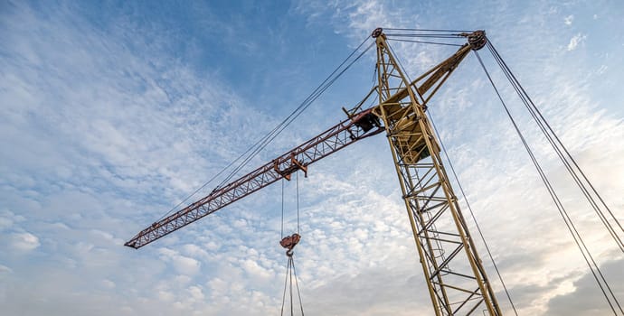 A low angle shot of a crane with equipment on a construction site near a new building infrastructure