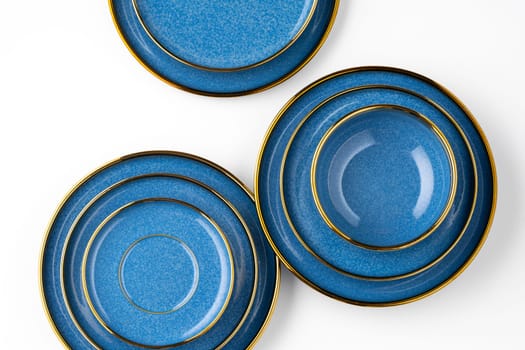 A set of blue ceramic plates on a white background. Top view