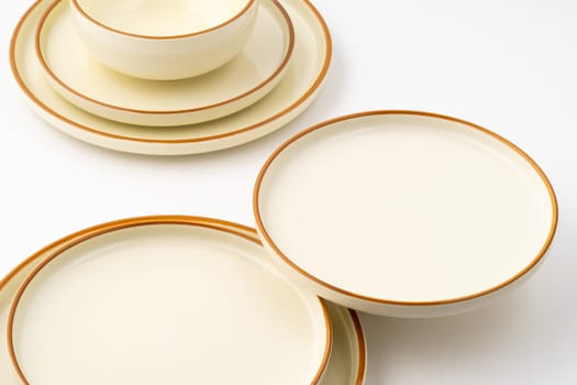 A set of white and brown ceramic plate and bowl on a white background