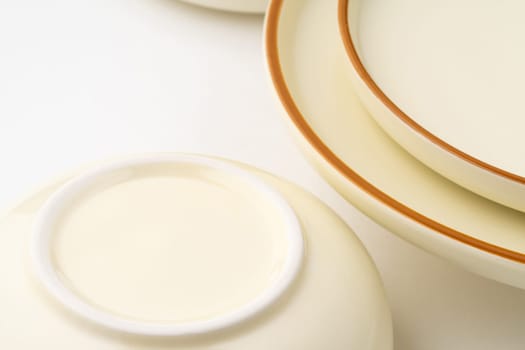 A set of white and brown ceramic plate and bowl on a white background. Close-up